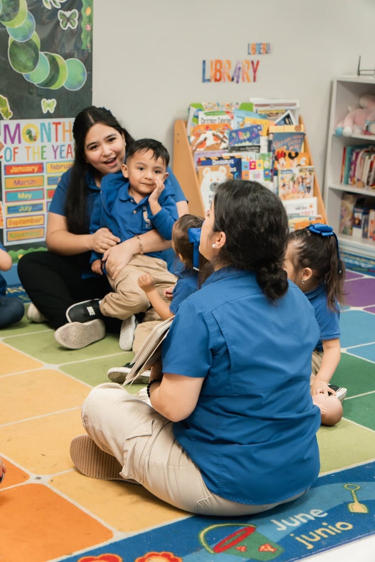 Teacher in blue shirt reading to young children sitting on colorful classroom mat in library area